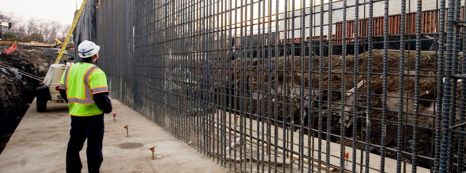 Rebar lined up on wall while employee examines